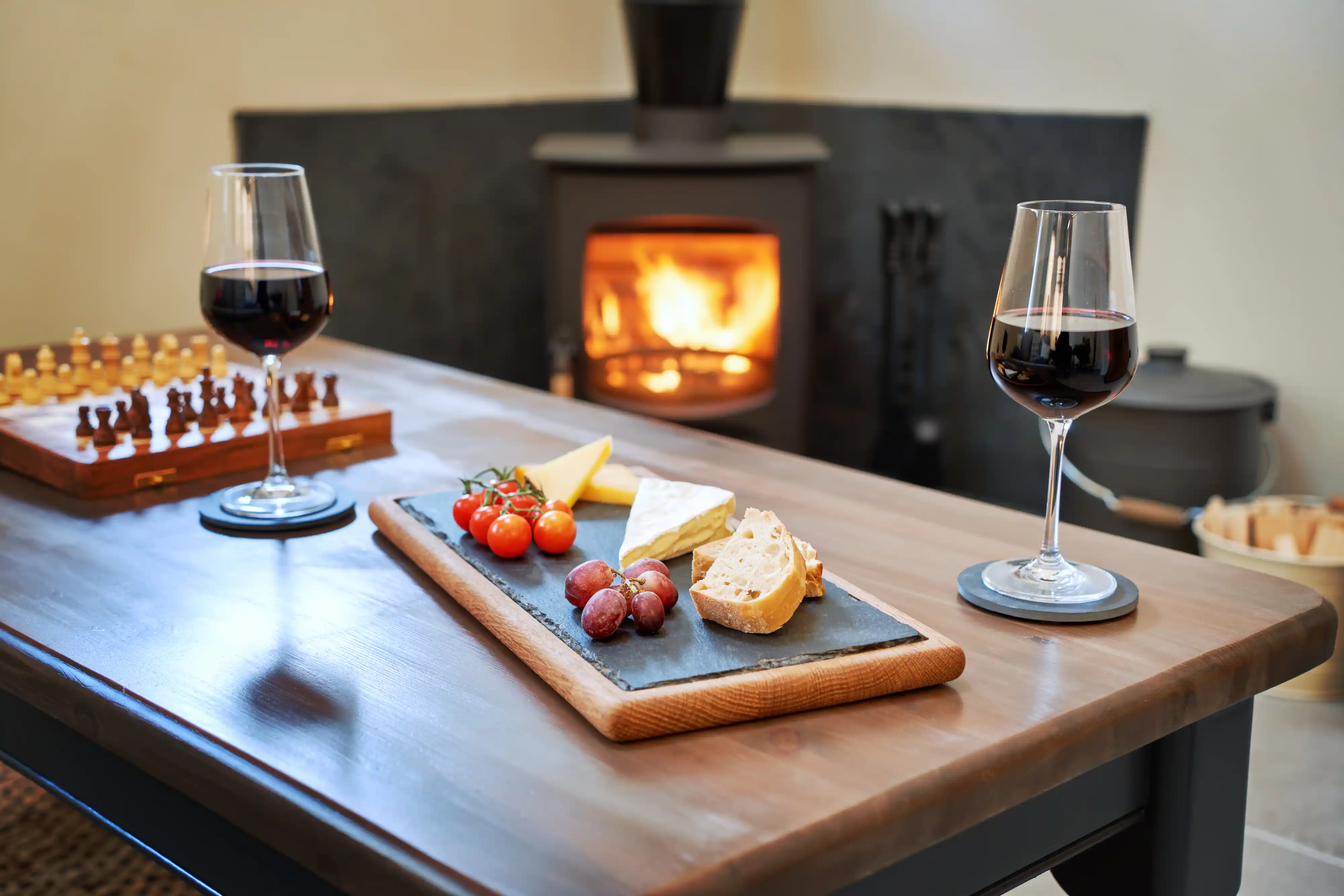 Cheeseboard and wine before a woodburning stove